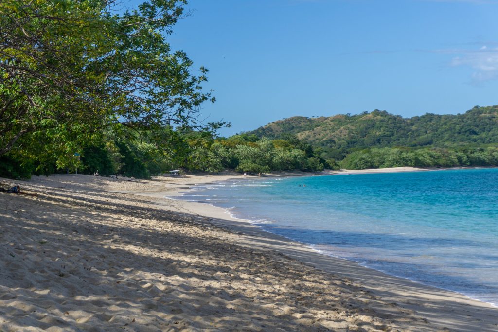 Scenic view of Playa Brasilito’s shoreline with clear blue water and soft sand, highlighting nearby Playa Brasilito property for sale.