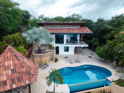 Casa Vista Penca ocean-view home with red tile roof, pool, balcony, and tropical landscaping in Playa Potrero, Costa Rica
