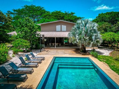 Casa Edén Tamarindo pool and garden view with lounge chairs and covered terrace in a peaceful Costa Rica setting