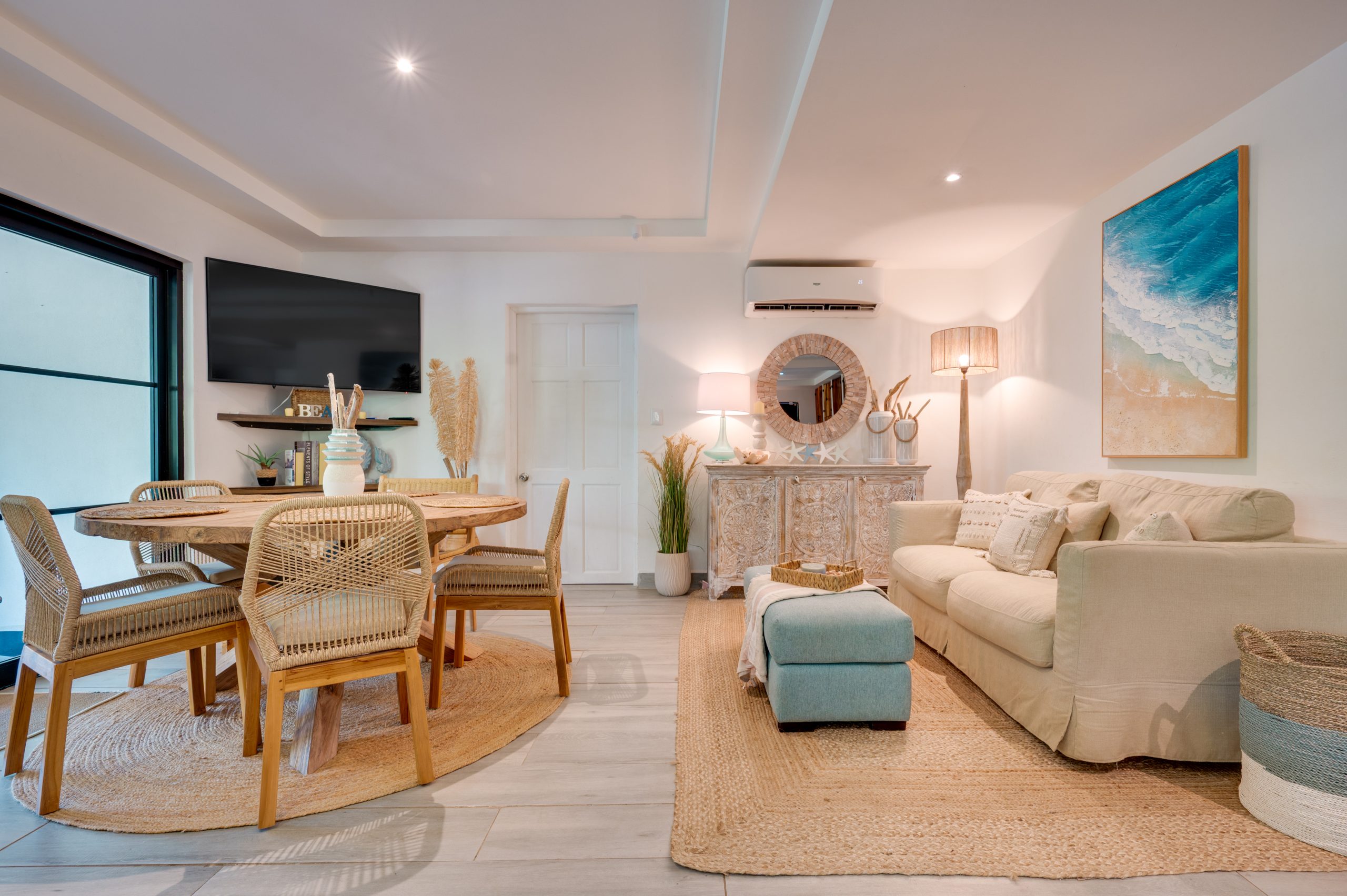 Living and dining area at Casa Tranquilo Montañas de Conchal with coastal decor, wood table, and open interior design