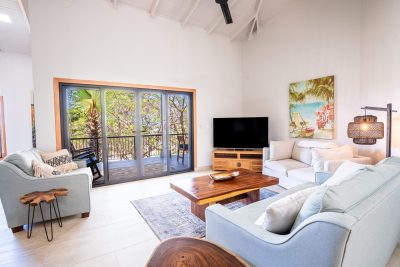 Modern living room at The Penthouse at Surfside Tower with balcony view of palm trees