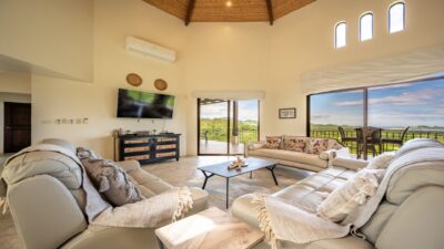 Living room with vaulted wood ceiling, large windows, and ocean views in Vistas de Flamingo, Potrero