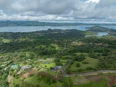 Aerial view of Marenal Gated Community in Nuevo Arenal with Lake Arenal in the background and lush green hillsides.