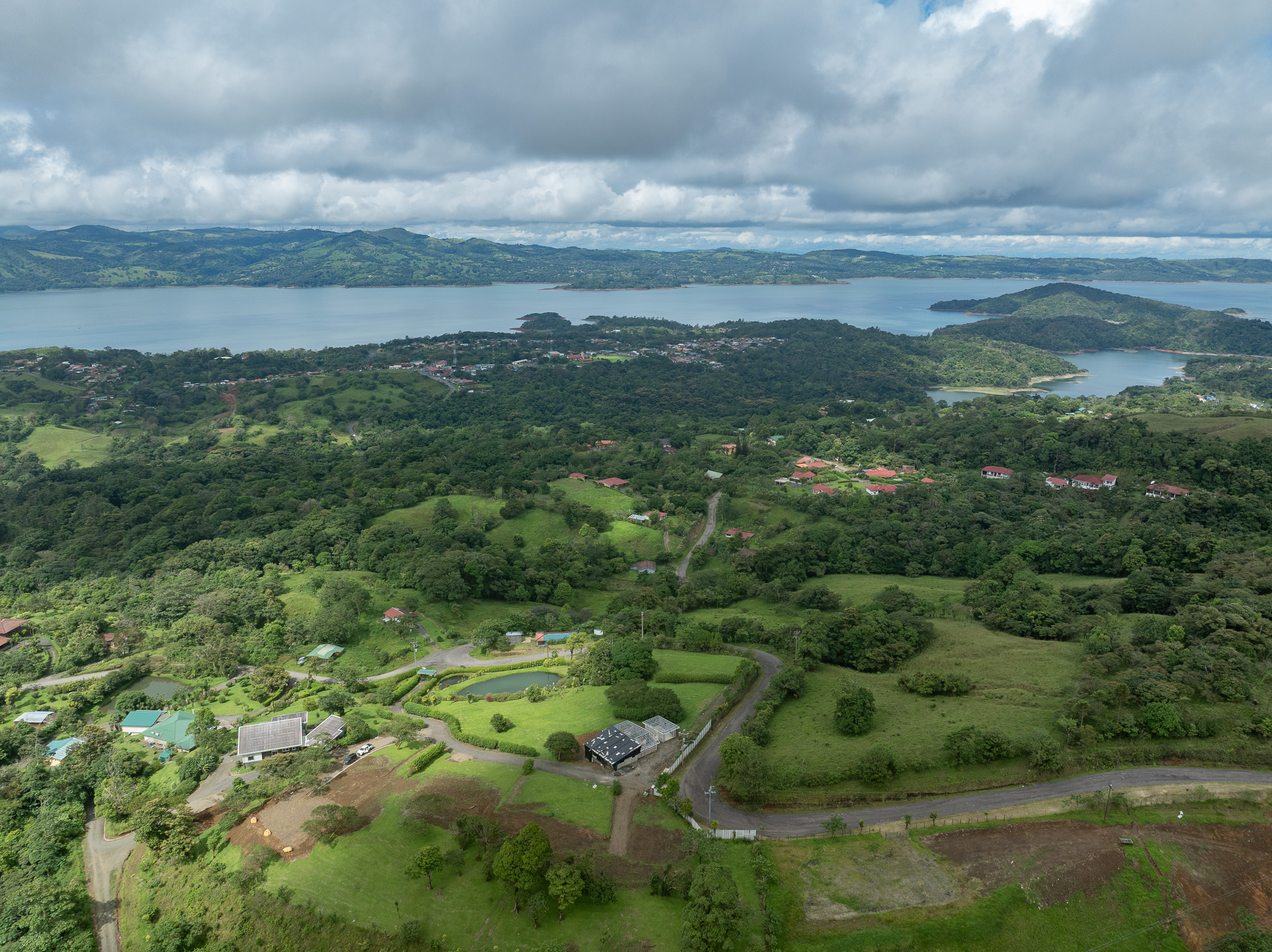 Aerial view of Marenal Gated Community in Nuevo Arenal with Lake Arenal in the background and lush green hillsides.