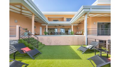 Terraced outdoor patio with lounge chairs and covered balcony at Villa Chiric Tamarindo hilltop home