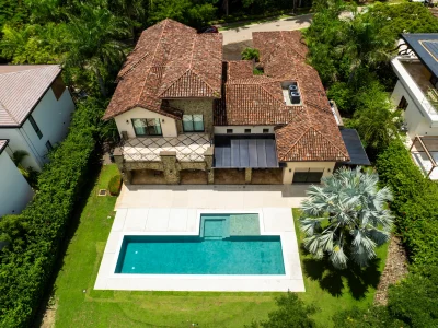 Aerial view of La Dulce Vida 7 Hacienda Pinilla with tile roof, courtyard layout, and rectangular pool beside the fairway