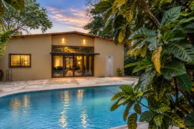 Rancho Golondrinas exterior with private pool, tropical landscaping, covered patio, and warm evening lighting.