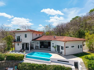 Casa Por Fin, a modern two-story home with an infinity-edge pool and lush natural surroundings in Rancho Villarreal.