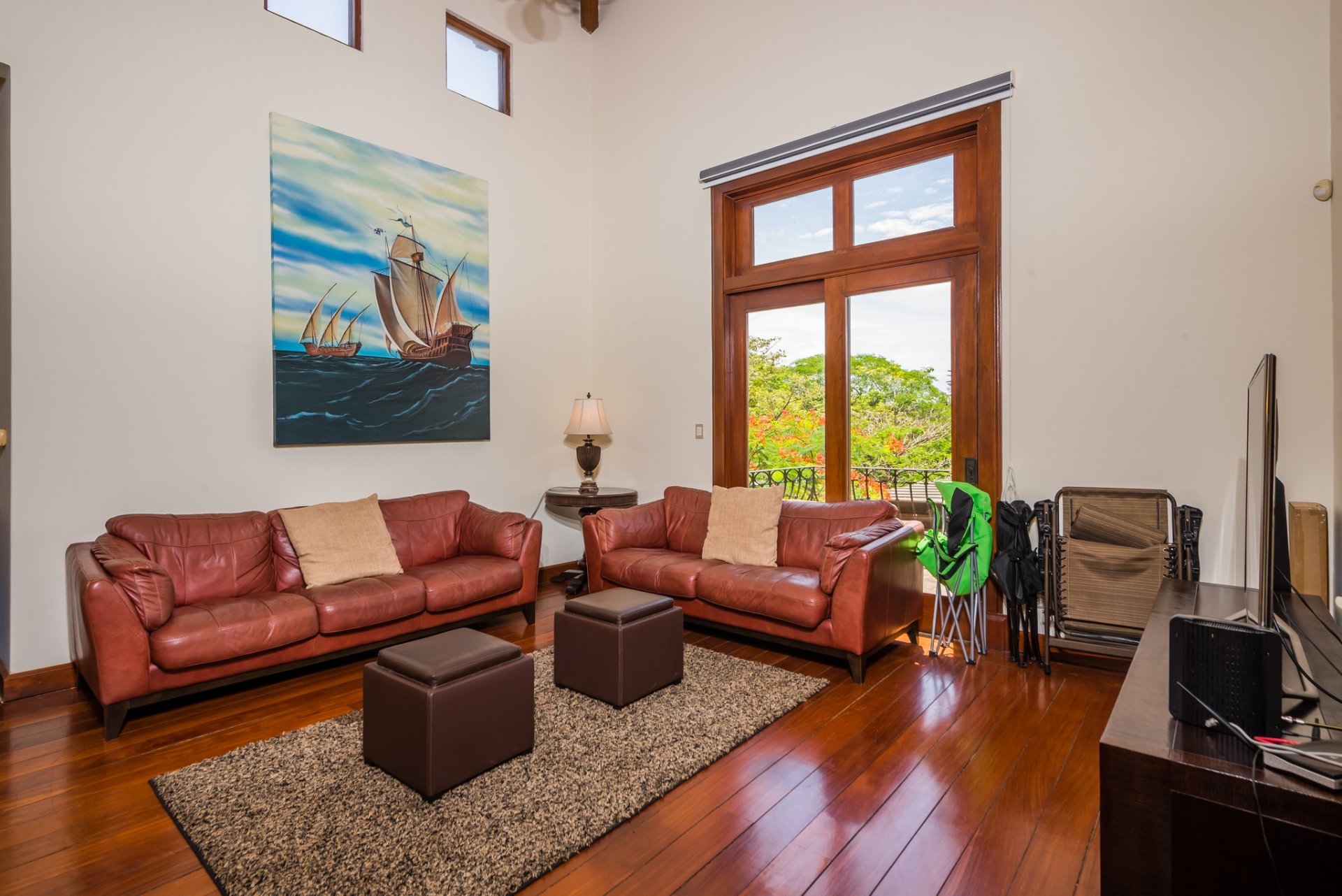 Media room with red couches, large window, and wall art in luxury home, Hacienda Pinilla, Costa Rica Real Estate Cr