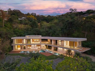 Modern two-level ocean view estate in Tamarindo with infinity pool and hillside tropical setting at sunset