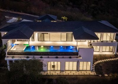 Evening exterior of Villa Amanzi in Mar Vista Flamingo with illuminated infinity pool and expansive terraces