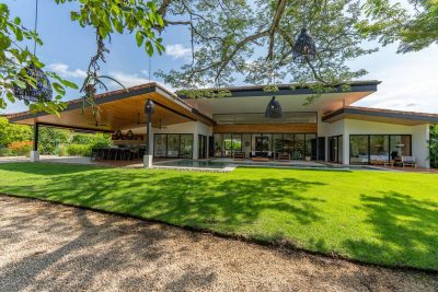 Casa Almendra Hacienda Pinilla modern tropical home exterior with open living areas, pool terrace, and landscaped lawn