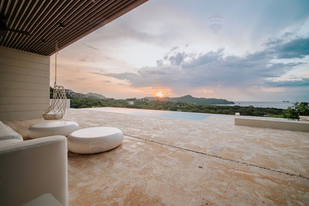 Infinity-edge pool blending into Pacific sunset at Cortez Amarillo — Costa Rica Real Estate CR