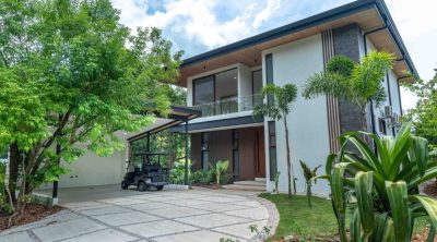 Modern two-story Mar Pacifico home with tropical landscaping and carport in Playas del Coco, Costa Rica.
