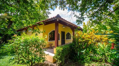 Cozy yellow villa in Villaggio Flor del Pacifico, Playa Potrero surrounded by tropical gardens and greenery