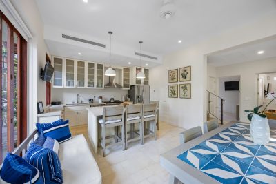 Open kitchen and dining area at 25 Paseo Del Mar Las Catalinas, a Playa Danta beachfront home with island seating and glass cabinetry.
