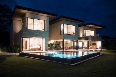 Casa Guayacán by Costa Rica Real Estate CR, luxury Hacienda Pinilla home with pool at night