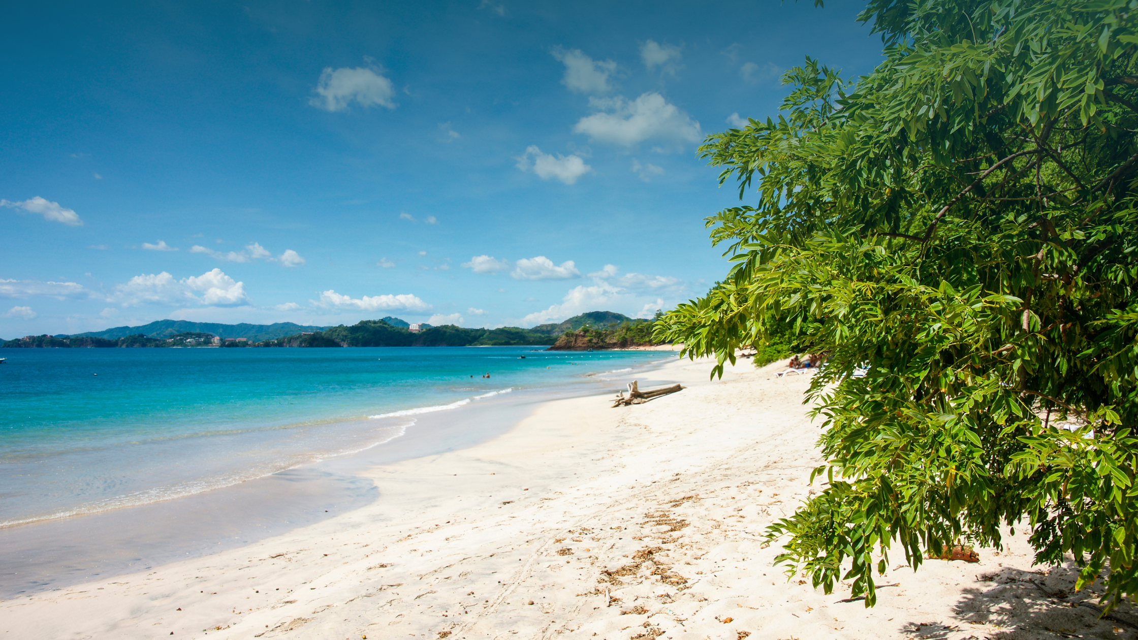 Turquoise Playa Conchal shoreline with white sand and lush greenery, highlighting the Playa Conchal Costa Rica real estate lifestyle