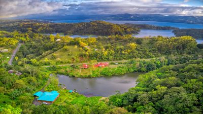 Aerial view of Lake Arenal and Nuevo Arenal Real Estate homes surrounded by lush Costa Rican hills.
