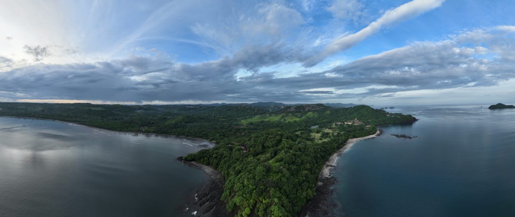 Aerial view of Catalina Cove Costa Rica real estate near Playa Brasilito, surrounded by lush hills and Pacific Ocean waters.