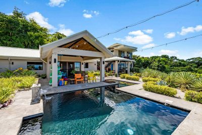 Casa Arcadia poolside terrace with tropical landscaping and ocean-view design.