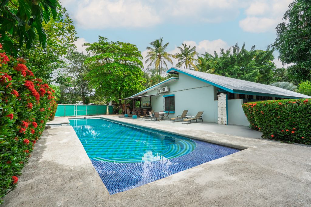 Almond Tree Costa Rica rental income property with large pool, lounge seating, and tropical landscaping in Surfside Potrero