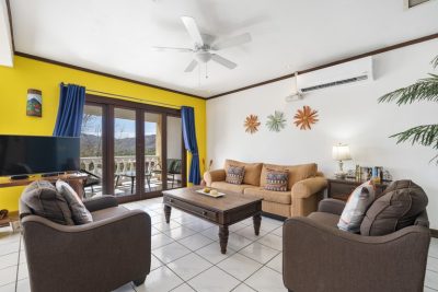 Bright living room with open-concept layout and balcony access at Marina Real 122 across from Flamingo Marina