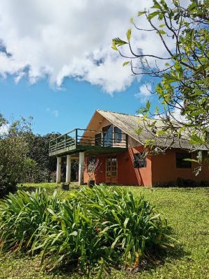 A-frame mountain home with raised balcony, tropical garden, and sloped roof set on landscaped grounds near Nuevo Arenal, Costa Rica