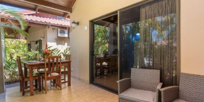 Covered patio with seating and dining area opening to interior living space at Villagio Claudia 21A Playa Potrero Costa Rica