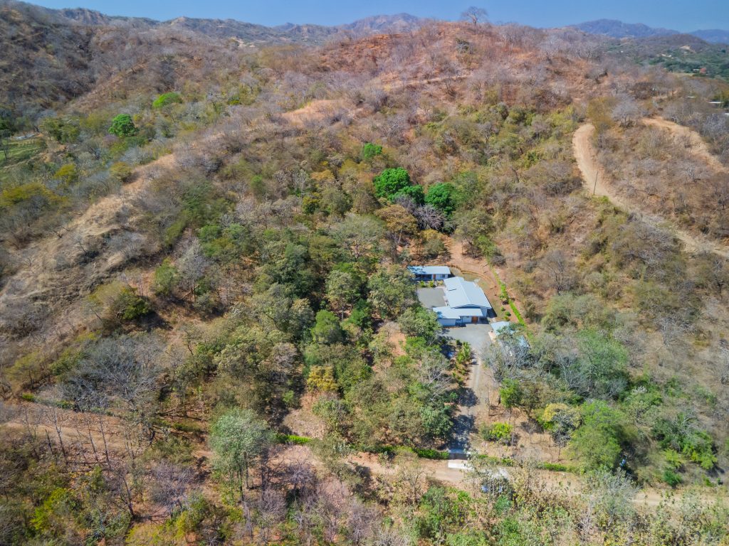 Wide aerial view of Casa Los Sueños hillside setting and surrounding land in Portegolpe Guanacaste