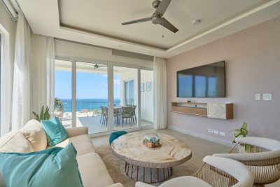 Living room with sliding glass doors to ocean-view balcony at La Vista Condos Tamarindo
