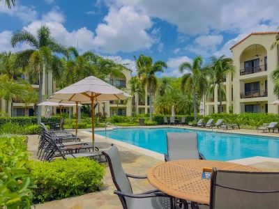 Pool courtyard at Pacifico Townhouse 101 in Playas del Coco with loungers, palms, and resort pool — Pacifico townhouse Playas del Coco