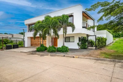 Casa Offshore Playa Tamarindo modern exterior with garage and tropical landscaping, a Costa Rica coastal home near the beach