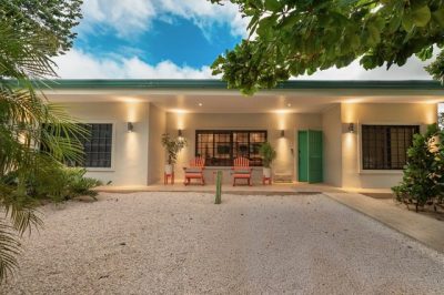 Front view of Dual Home Tamarindo with covered patio, outdoor seating, and garden, home near Tamarindo beach