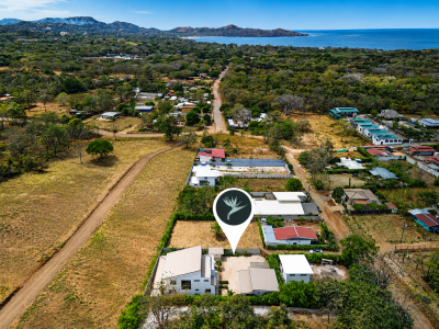 Aerial view of Casa Selamar in Brasilito, marked below the coastline with surrounding homes, roads, and tropical hills.