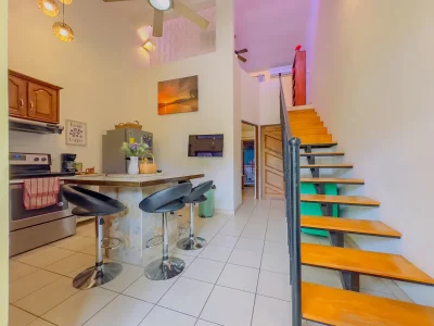 Flamenco Rosa C20 Playas del Coco loft condo interior with kitchen and stairs, Guanacaste condo with pool