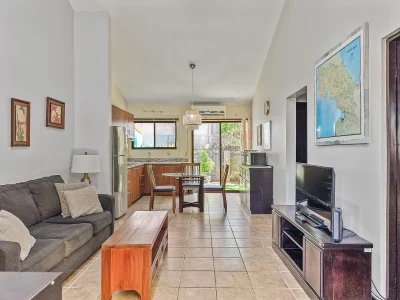 Cormoran A6 Playas del Coco living area with kitchen and dining space, condo with pool Costa Rica