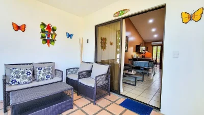 Jade Beach C64 Playas del Coco screened terrace seating area opening to interior, Playas del Coco walkable condo