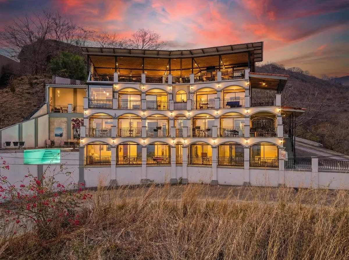 Lookout Suites ocean-view hotel in Playas del Coco at sunset with terraces, pool, and hillside setting