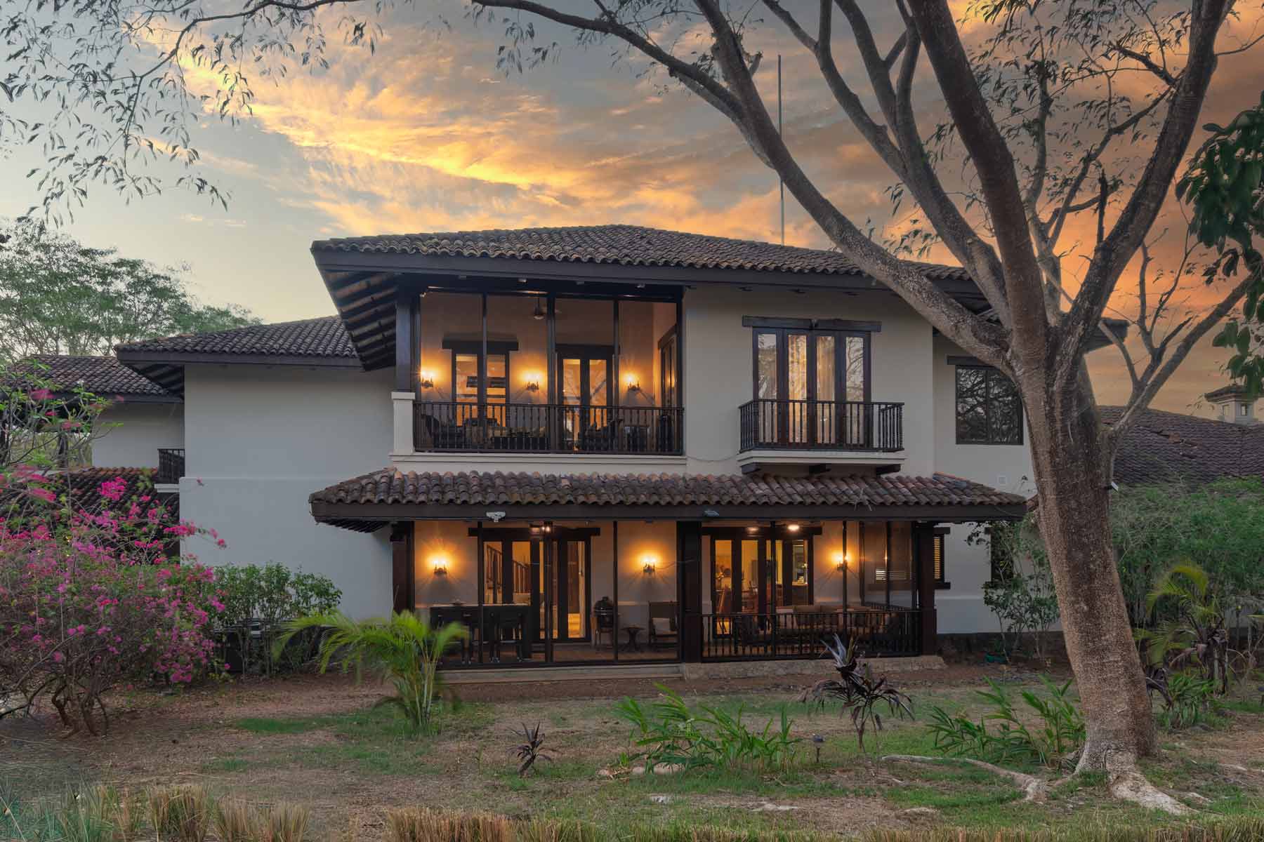 Los Malinches 22 two-level Spanish colonial home in Hacienda Pinilla at sunset with terraces and garden