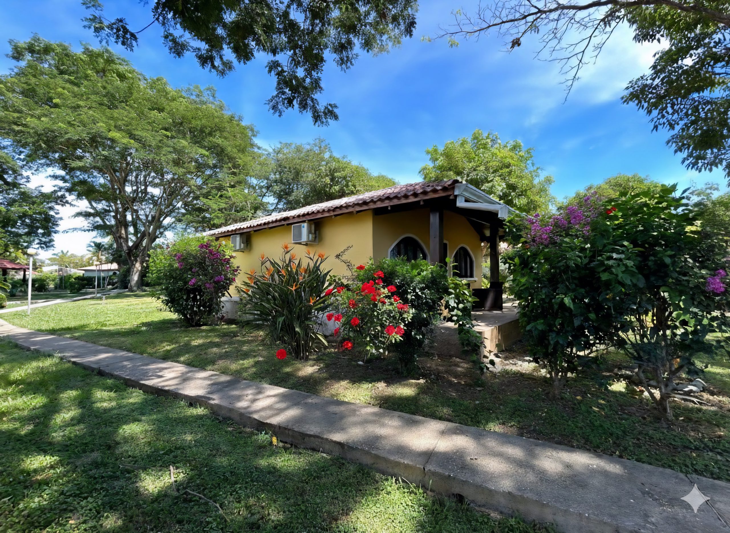 Villagio 2 Unit 408 exterior garden setting in Playa Potrero Costa Rica with shaded walkway and landscaped yard