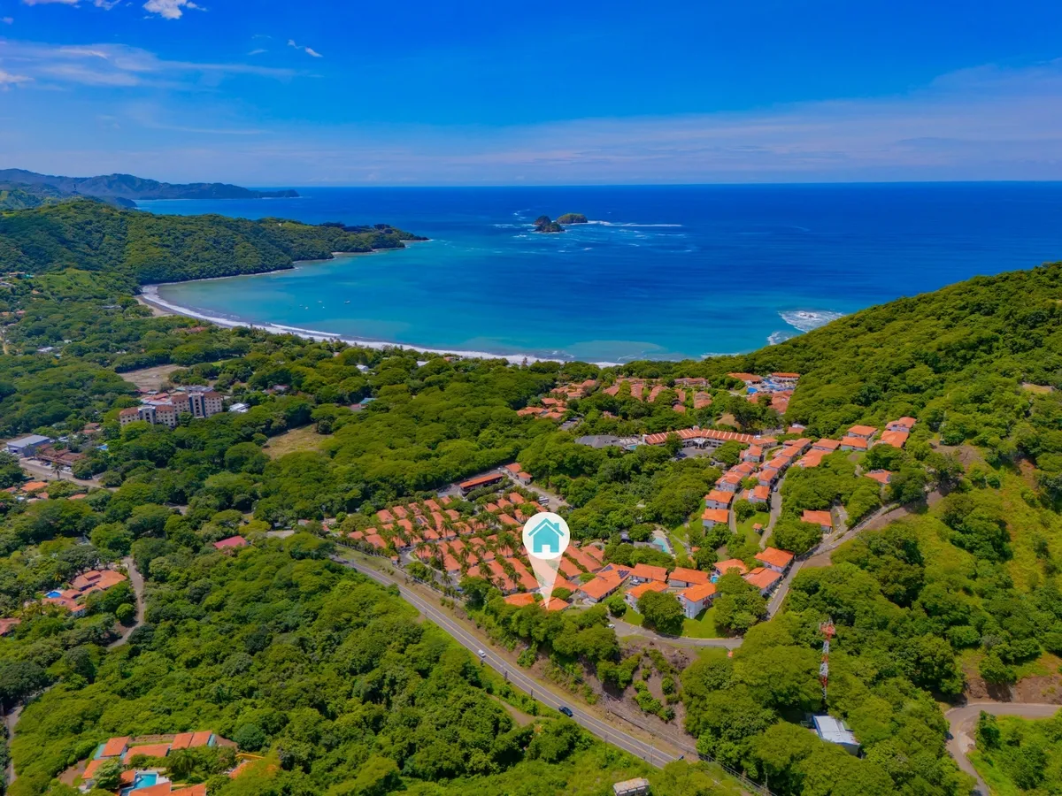 Aerial view of Villas Sol 57-1 in Playa Hermosa overlooking ocean and resort-style coastal community in Guanacaste