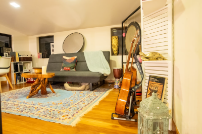 Casa Lunax Ocean View Residence loft sitting area with sofa, guitar, and wood accents in a tropical home near Tamarindo