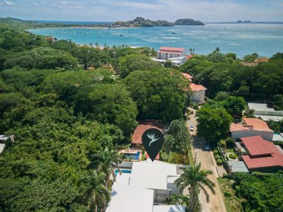 Aerial view of Casa Marina marked among tropical trees near Playa Potrero Bay and the Pacific coastline.