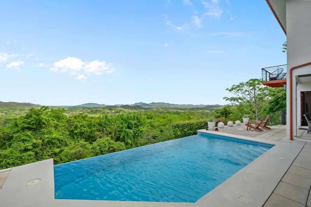 Infinity pool and terrace with hillside and ocean views at a luxury villa in Guanacaste, Costa Rica