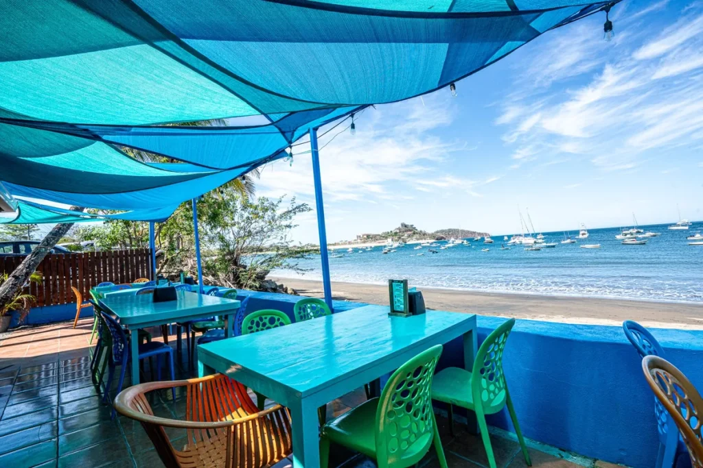 Beachfront restaurant terrace on Playa Potrero, with sailboats anchored in Potrero Bay, Guanacaste, Costa Rica