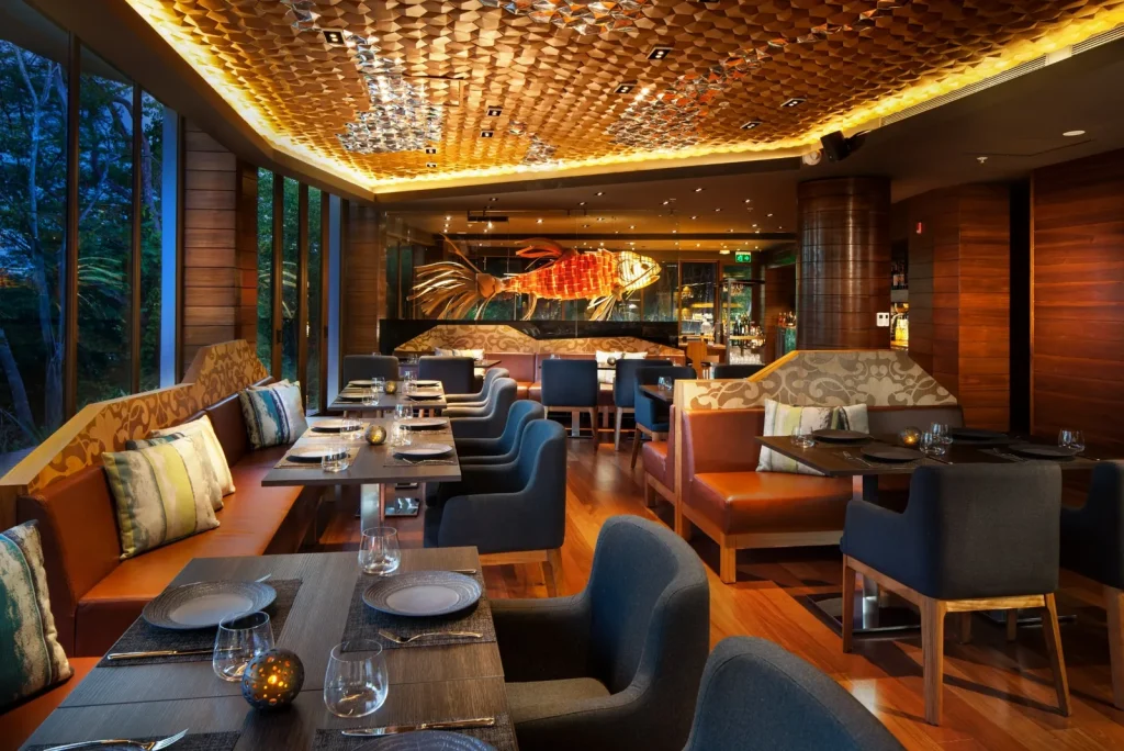 Interior of Latitud 10° Norte restaurant at the W Costa Rica, Reserva Conchal, with warm lighting and fine dining table settings