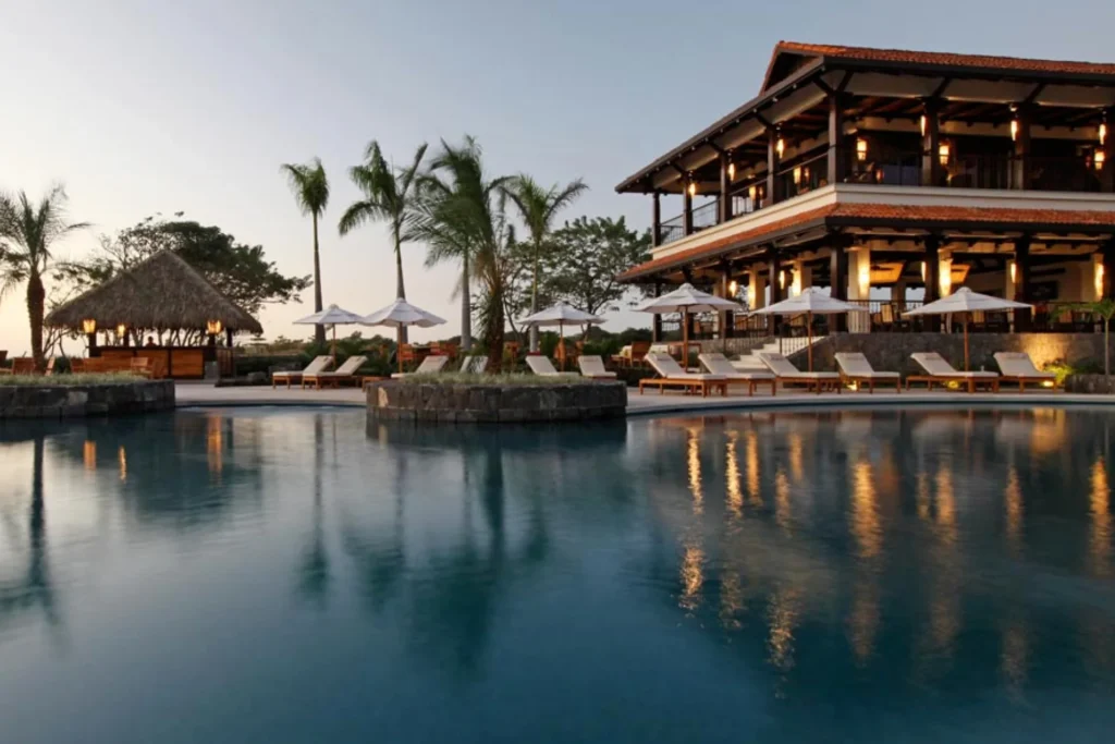 Infinity pool and open-air clubhouse at dusk in Hacienda Pinilla, Guanacaste, Costa Rica