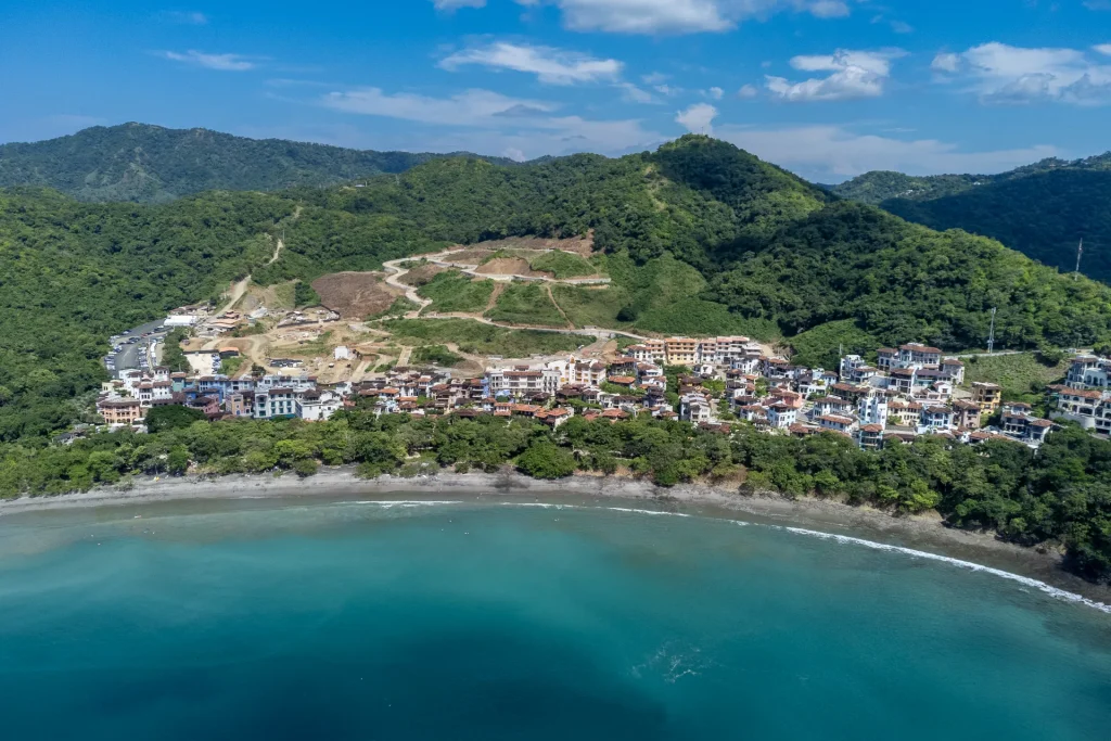 Aerial view of Las Catalinas, Costa Rica, a car-free beach town above Playa Danta with forested hills behind