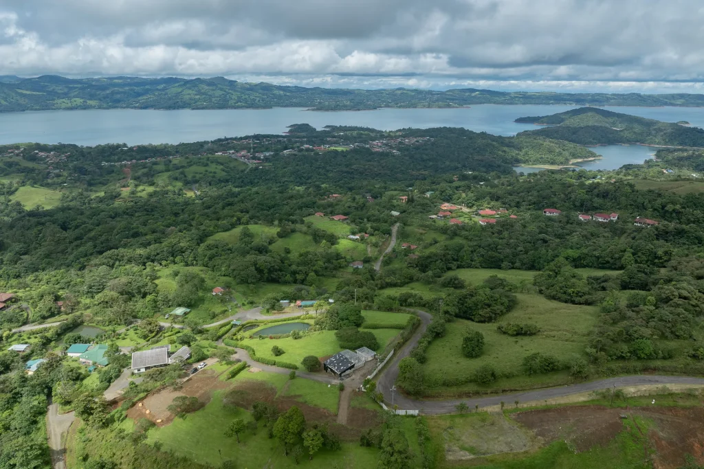 Aerial view of Marenal homesites and paved roads above Nuevo Arenal and Lake Arenal